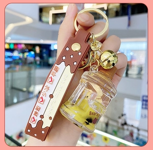 Close-up of bear's milk tea liquid keychain with brown silicone strap and yellow cup