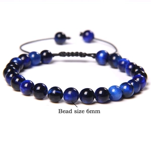 Macro shot of 6mm blue tiger eye beads on an adjustable braided cord bracelet