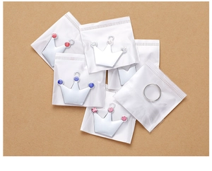 Close-up of crown-shaped zinc alloy pet tags with colorful rhinestones in packaging