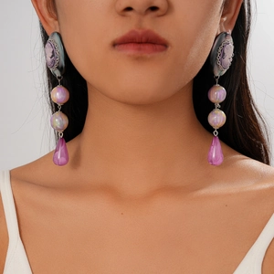 Detail shot of vintage resin cameo earrings with purple drop pendants on a model