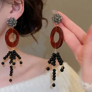 Vintage oval crystal tassel earrings with gray stones and black beads on a model