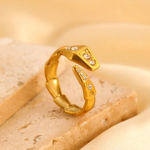 Macro-opname van een gouden slangenvormige verstelbare ring met kristallen op steen