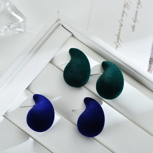 Detail of dark green and royal blue flocked teardrop earrings with velvet texture