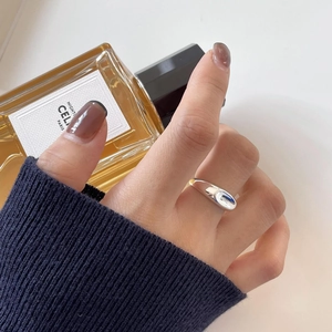 Irregular liquid metal silver ring detail showing smooth polished texture on finger
