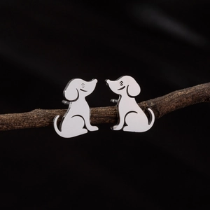 Cute minimalist puppy stud earrings in polished silver finish on a wooden branch background