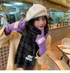 Detail of purple knitted touchscreen gloves paired with a colorful checkered scarf