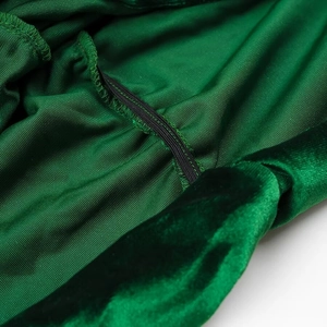 Detailopname van de groene fluwelen stofstructuur en de professionele stiksels op de jurk