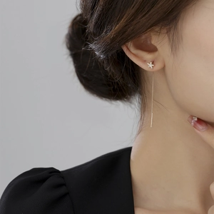 Macro shot of a sparkling star-shaped ear threader with cubic zirconia on a model