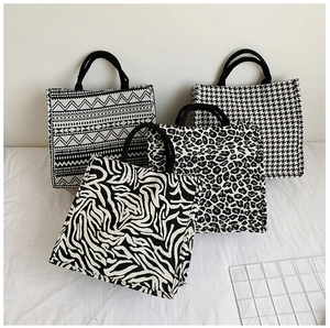 Detail view of four canvas tote bags with zebra, leopard, and houndstooth patterns