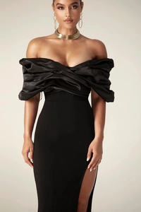 Detail of elegant black off-shoulder evening dress with pleated bodice and side slit
