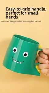 Close-up of a child holding the ergonomic green dinosaur cup handle with yellow spikes
