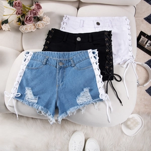 Dettaglio degli shorts in denim a vita alta con design trendy con lacci laterali