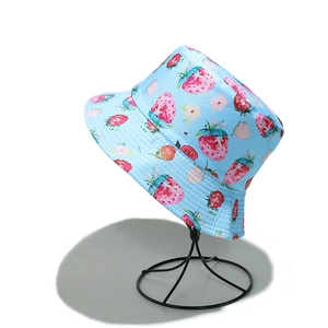 Detail view of light blue sun hat with pink strawberry and floral print on cotton fabric