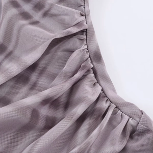 Macro detail of dusty purple mesh fabric with intricate shirred pleats on the dress