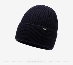 Detailed knit texture of dark winter beanie featuring silver logo patch and ribbed cuff