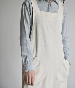Detail of beige linen apron featuring large functional side pockets and soft washed texture