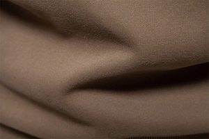 Macro detail of dark khaki cotton fabric showing soft texture and fine knitting pattern