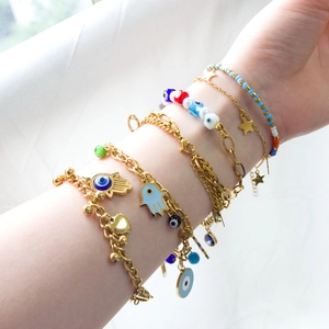 Hamsa Hand and Evil Eye gold beaded charm bracelet stack set for women on white background