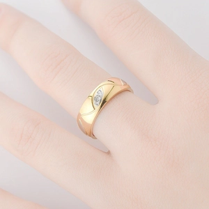 Macro shot of 18K gold-plated tricolor ring with wavy texture and three-stone setting