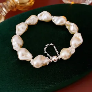 Baroque pearl bracelet with magnetic silver clasp and safety chain on green velvet