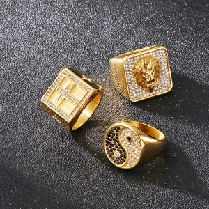 Detailed macro view of three gold rings with lion head, cross, and tai chi crystal patterns