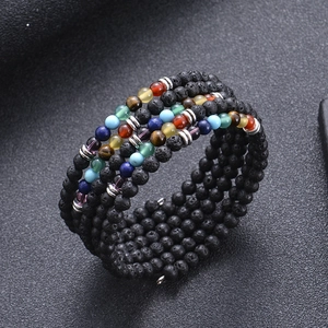 Detailed close-up of 6mm lava rock beads and colorful chakra stones on a layered bracelet