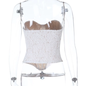 Detail of white ruched tube top featuring elastic smocked texture and stretchy fabric