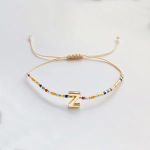 Details des verstellbaren Boho-Perlenarmbands mit goldenem Z-Anhänger und bunten Glasperlen