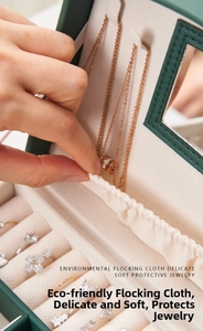 Detailed view of dark green jewelry box featuring ring slots and soft velvet lining
