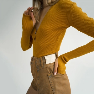Close-up of ginger yellow V-neck knitted bodysuit featuring ribbed fabric and button detail