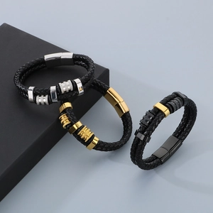 Détail d'un bracelet en cuir tressé multicouche avec fermoirs magnétiques argentés, dorés et noirs