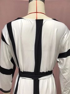Detail view of the black and white geometric striped dress back with waist tie design