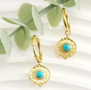 Close-up of gold 18K stainless steel sunburst earrings with blue turquoise inlay