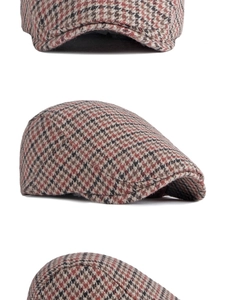 Détail macro du motif pied-de-poule en laine et des coutures sur la casquette plate