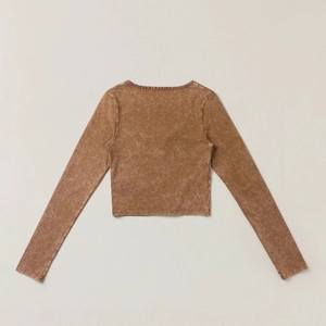 Dettaglio cardigan marrone a maniche lunghe con effetto acido e taglio cropped