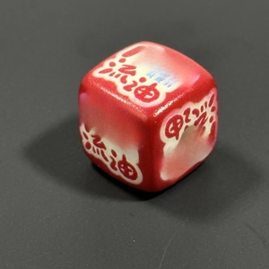 Detail of red acrylic cube bead with creative food-style typography and smooth finish