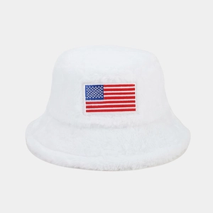 Détail d'un bob en fausse fourrure blanche avec broderie du drapeau américain