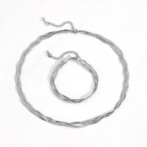 Close-up of silver braided necklace and bracelet set with lobster clasp detail