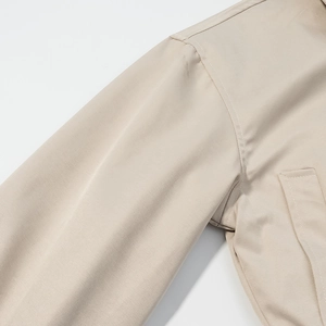 Detailed macro view of the beige zipper jacket shoulder seam and fine twill fabric texture
