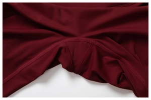 Détail macro du gousset et des coutures renforcées sur un pantalon de yoga bordeaux