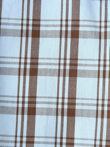 Macro view of brown and white checkered poplin fabric texture on cotton shirt