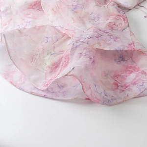 Detail van de organza ruches met bloemenprint op de zoom van de roze mini-jurk