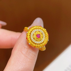 Détail macro d'une bague vintage en or 24k avec zircon rouge et travail de filigrane fin