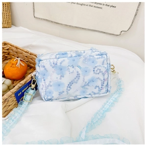 Detail of light blue floral sequin girls crossbody bag with ruffled strap and gold hardware