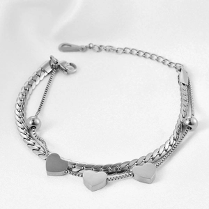 Detail of silver double-layered curb chain bracelet with solid heart pendants
