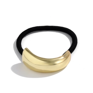 Detail of minimalist elastic hair tie with polished gold crescent metal decoration