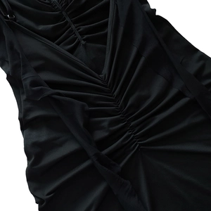 Gros plan détaillé sur le tissu froncé noir élégant d'une robe de soirée sexy ajustée