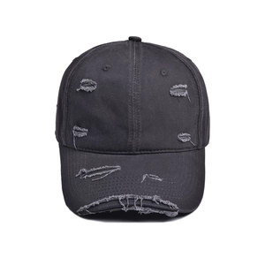 Detailed close-up of charcoal gray distressed baseball cap with vintage frayed holes
