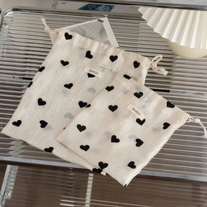 Close-up of heart pattern drawstring pouches with JIMEIZI label and cotton ropes