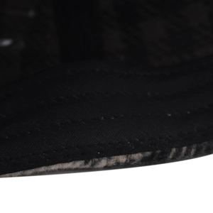 Macro detail of houndstooth baseball cap showing triple reinforced stitching and fleece lining